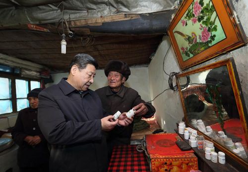 2012年12月30日，習(xí)近平在龍泉關(guān)鎮(zhèn)駱駝灣村困難群眾唐榮斌家，詳細(xì)詢問身體有病的唐榮斌（右）日常服藥情況。