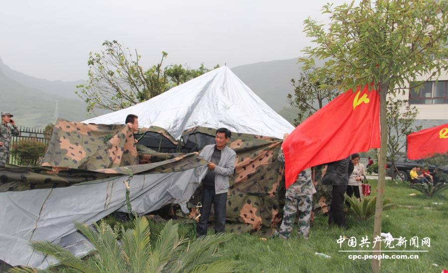 黨員干部在龍門鄉(xiāng)安置點幫助群眾搭建帳篷