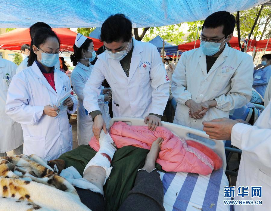  4月21日，北京大學(xué)第三醫(yī)院的專家在四川雅安市第二人民醫(yī)院為地震災(zāi)區(qū)的傷員治療。新華社記者陳樹根攝