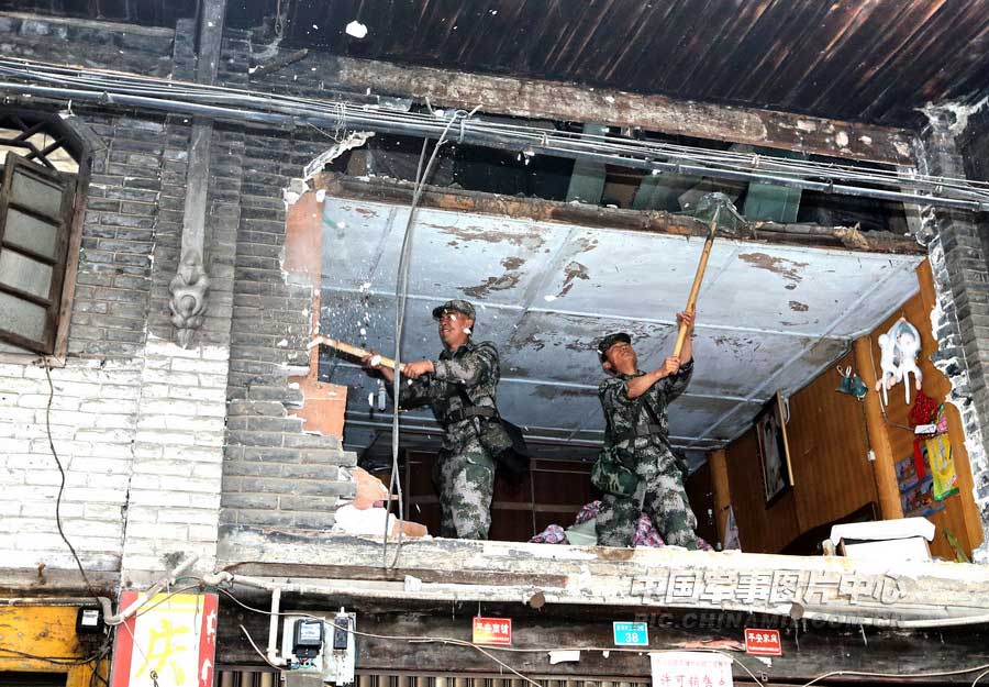 4月21日上午，記者在蘆山地震中心災區太平鎮，攝下了13集團軍某炮兵團官兵興清理廢墟路障的情景。