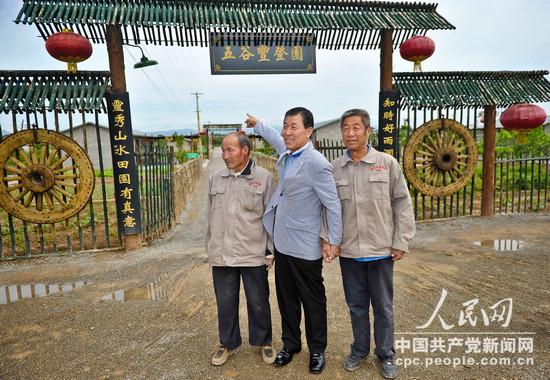 韓國議員黃震夏（中）緊抓兩位白縣農民並求記者收錄“五谷豐登園”背景(崔小粟攝)