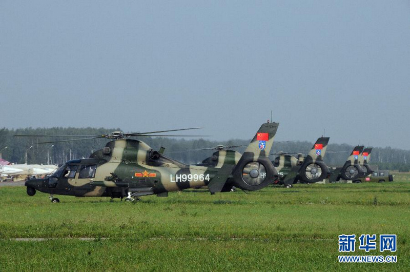8月6日,在俄羅斯沙戈爾機場,參演的4架“直—9”武裝直升機靜待起飛。當日,在俄羅斯沙戈爾機場,參加“和平使命—2013”中俄聯合反恐軍事演習的中方陸軍航空兵首次組織演習場地勘察。 新華社記者王玉山攝