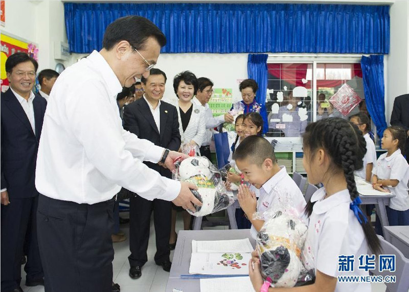 10月13日，正在泰國(guó)訪問(wèn)的國(guó)務(wù)院總理李克強(qiáng)參觀具有110多年歷史的清邁崇華新生華立學(xué)校。這是李克強(qiáng)向三年級(jí)學(xué)生贈(zèng)送大熊貓玩具。新華社記者 黃敬文 攝