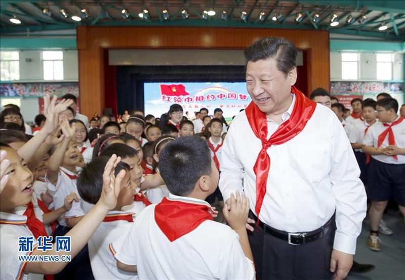 2014年5月30日上午，習近平來到北京市海澱區民族小學，參加慶祝“六一”國際兒童節活動。這是習近平在參加少先隊入隊儀式時，向少先隊員們致以節日問候。新華社記者 鞠鵬 攝