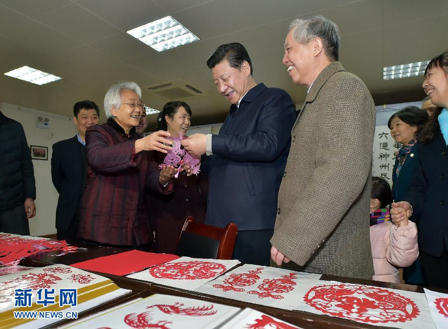 2月15日上午，習(xí)近平在西安市雁塔區(qū)電子城街道二〇五所社區(qū)服務(wù)中心欣賞社區(qū)老人的剪紙作品。新華社記者 李濤 攝