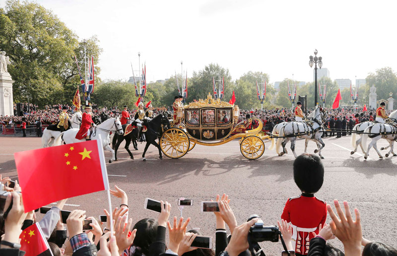 10月20日，對英國進行國事訪問的國家主席習近平出席英國女王伊麗莎白二世在倫敦騎兵檢閱場舉行的隆重歡迎儀式。這是習近平和夫人彭麗媛在女王夫婦陪同下，乘坐皇家馬車前往白金漢宮下榻。新華社記者 周磊 攝