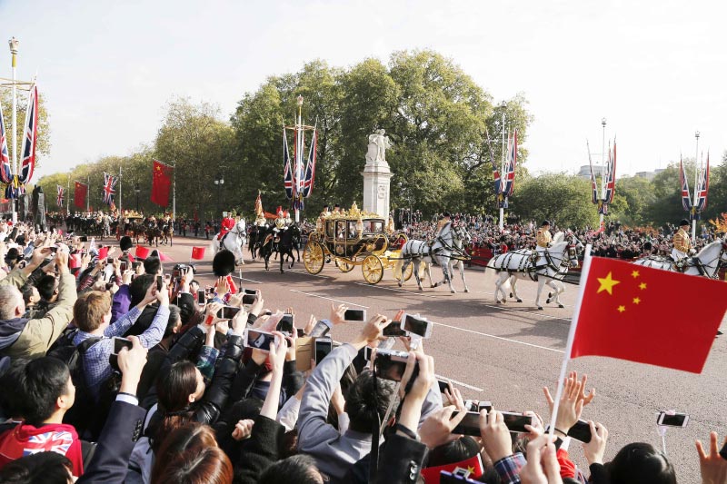 10月20日，對英國進行國事訪問的國家主席習近平出席英國女王伊麗莎白二世在倫敦騎兵檢閱場舉行的隆重歡迎儀式。這是習近平和夫人彭麗媛在女王夫婦陪同下，乘坐皇家馬車前往白金漢宮下榻。新華社記者 周磊 攝