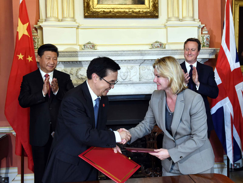10月21日，國家主席習近平在倫敦唐寧街首相府同英國首相卡梅倫舉行會談。這是會談結束后，兩國領導人共同見証雙邊合作文件的簽署。新華社記者 饒愛民 攝