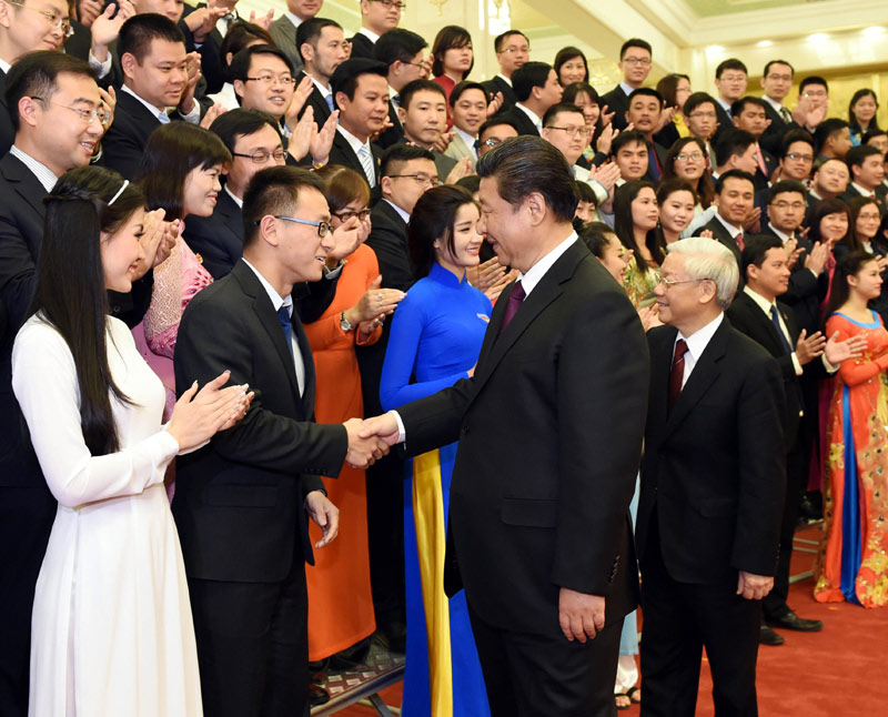 4月7日，中共中央總書記、國家主席習近平和越共中央總書記阮富仲在北京人民大會堂共同出席第十五屆中越青年友好會見活動，同兩國青年代表親切握手，合影留念。新華社記者饒愛民攝