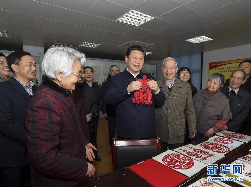 這是15日上午，習近平在西安市雁塔區電子城街道二〇五所社區服務中心，拿起一幅“三陽開泰”剪紙，祝願全國各族人民新春愉快、羊年大吉，生活喜氣洋洋，事業蒸蒸日上。新華社記者 李學仁 攝