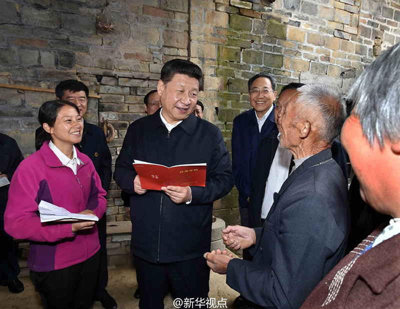 安徽省花石鄉(xiāng)大灣村，68歲的貧困戶汪能保看到習近平總書記沿著石階走向他家，快步迎了上去，緊緊握住總書記的手，激動不已。習近平拿起桌上的扶貧手冊，一邊看一邊詢問老汪家的情況。