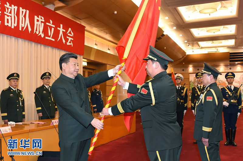 2015年12月31日，中國人民解放軍陸軍領導機構、中國人民解放軍火箭軍、中國人民解放軍戰略支援部隊成立大會在北京八一大樓隆重舉行。習近平向陸軍、火箭軍、戰略支援部隊授予軍旗並致訓詞。這是習近平將軍旗鄭重授予陸軍司令員李作成、政治委員劉雷。記者 李剛 攝