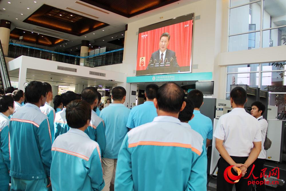 10月18日上午，海南三亞國際郵輪港干部職工和游客一起觀看黨的十九大開幕會。人民網(wǎng)吉羽 攝
