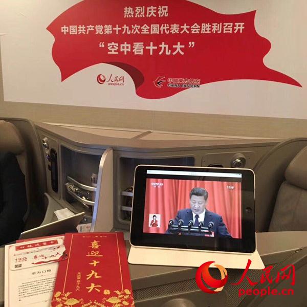 10月18日上午，在東方航空飛機上收看十九大開幕會。人民網(wǎng)宋麗雲(yún) 攝