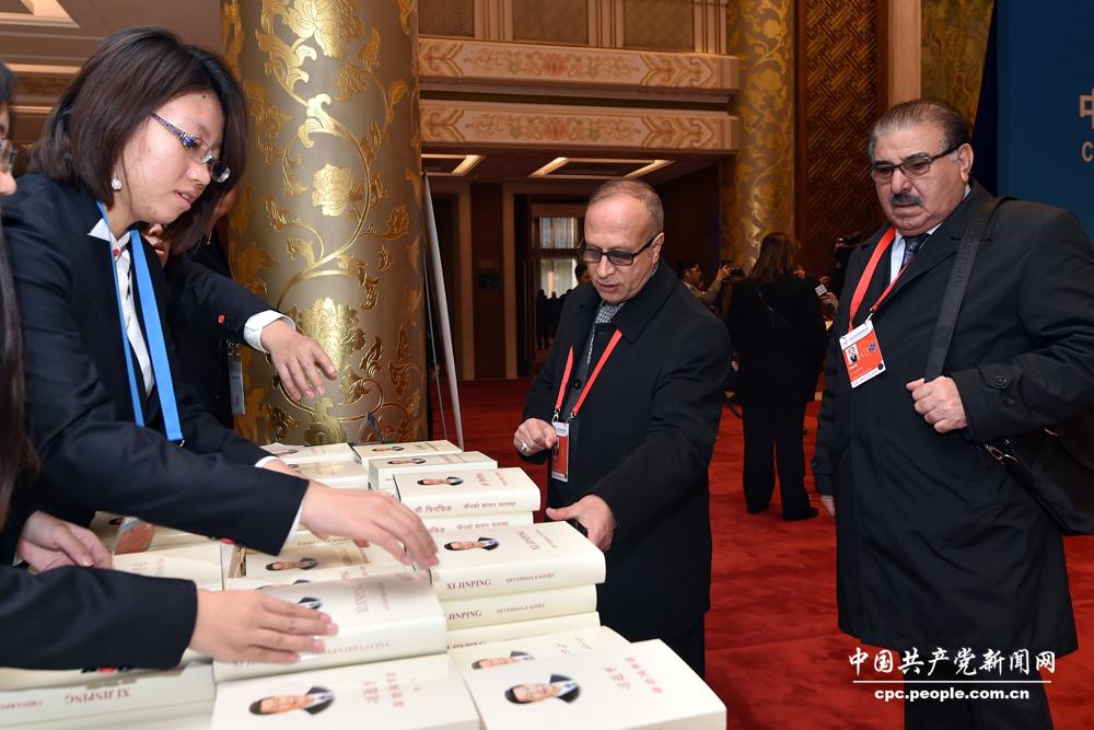 出席研討會(huì)的嘉賓領(lǐng)取《習(xí)近平談治國(guó)理政》叢書(shū)。（人民網(wǎng)記者 翁奇羽 攝）