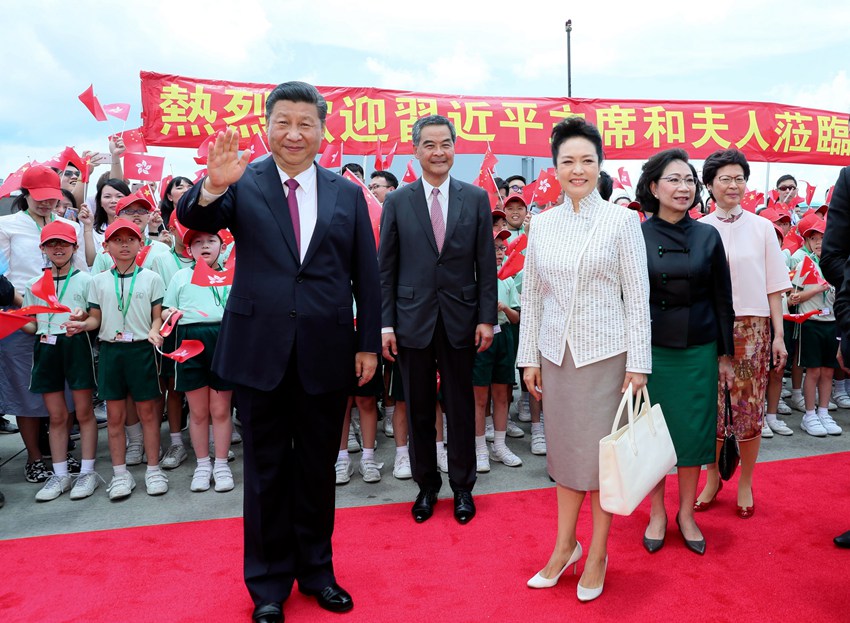 6月29日中午，中共中央總書記、國家主席、中央軍委主席習近平乘專機抵達香港，出席將於7月1日舉行的慶祝香港回歸祖國20周年大會暨香港特別行政區第五屆政府就職典禮並視察香港。這是習近平和夫人彭麗媛在機場向歡迎的人群致意。新華社記者 蘭紅光 攝