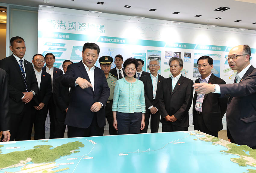 7月1日上午，國家主席習近平在香港特別行政區行政長官林鄭月娥陪同下，考察港珠澳大橋香港段建設工地和香港國際機場第三跑道建設情況。這是習近平來到香港國際機場，考察第三跑道建設情況，觀看展板和沙盤模型。 新華社記者 丁林 攝