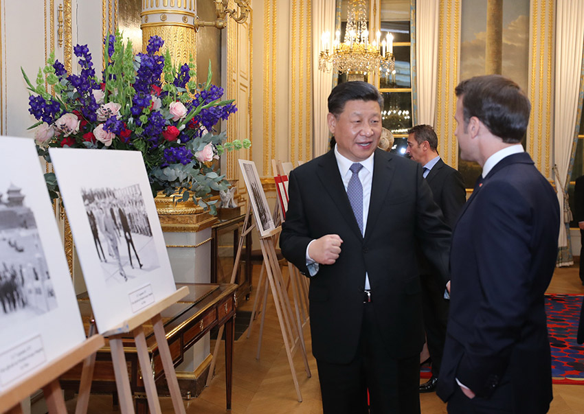 3月25日，國家主席習(xí)近平在巴黎愛麗舍宮同法國總統(tǒng)馬克龍參觀中法建交55周年和留法勤工儉學(xué)運(yùn)動100周年圖片展。 新華社記者 鞠鵬 攝