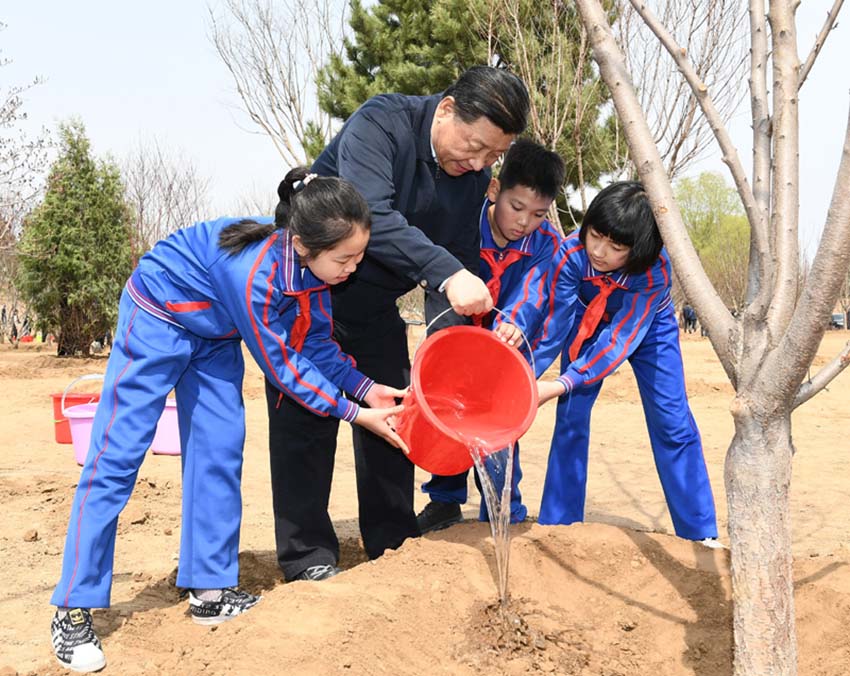 4月8日，黨和國家領導人習近平、栗戰書、汪洋、王滬寧、趙樂際、韓正、王岐山等來到北京市通州區永順鎮參加首都義務植樹活動。這是習近平同少先隊員一起給剛栽下的樹苗澆水。新華社記者 謝環馳 攝