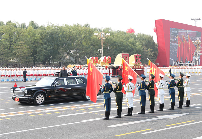 10月1日，慶祝中華人民共和國成立70周年大會(huì)在北京天安門廣場隆重舉行。中共中央總書記、國家主席、中央軍委主席習(xí)近平發(fā)表重要講話並檢閱受閱部隊(duì)。這是習(xí)近平驅(qū)車行進(jìn)至黨旗、國旗、軍旗前，向旗幟行注目禮。 新華社記者 丁海濤 攝