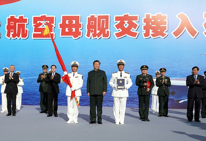 12月17日，我國第一艘國產航空母艦山東艦在海南三亞某軍港交付海軍。中共中央總書記、國家主席、中央軍委主席習近平出席交接入列儀式並登艦視察。這是習近平向海軍接艦部隊授予軍旗、命名証書。 新華社記者 李剛 攝
