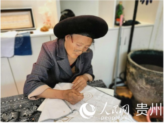 趙開英老人正在聚精會(huì)神地繪制產(chǎn)品圖案。人民網(wǎng) 王欽攝